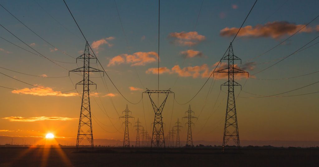 High-voltage transmission towers at sunset